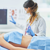 Doctor in mask doing ultrasound abdomen test to female patient